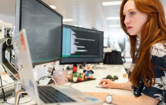 A woman in an office researching relationship mapping software on her computer